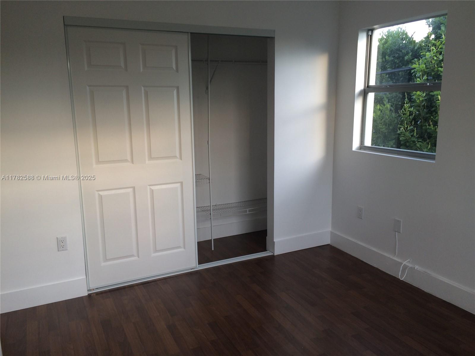 7025 Rue Granville, Unit 3 Miami Beach, FL 33141 - Photo 19 of 21 an empty room with wooden floor and windows