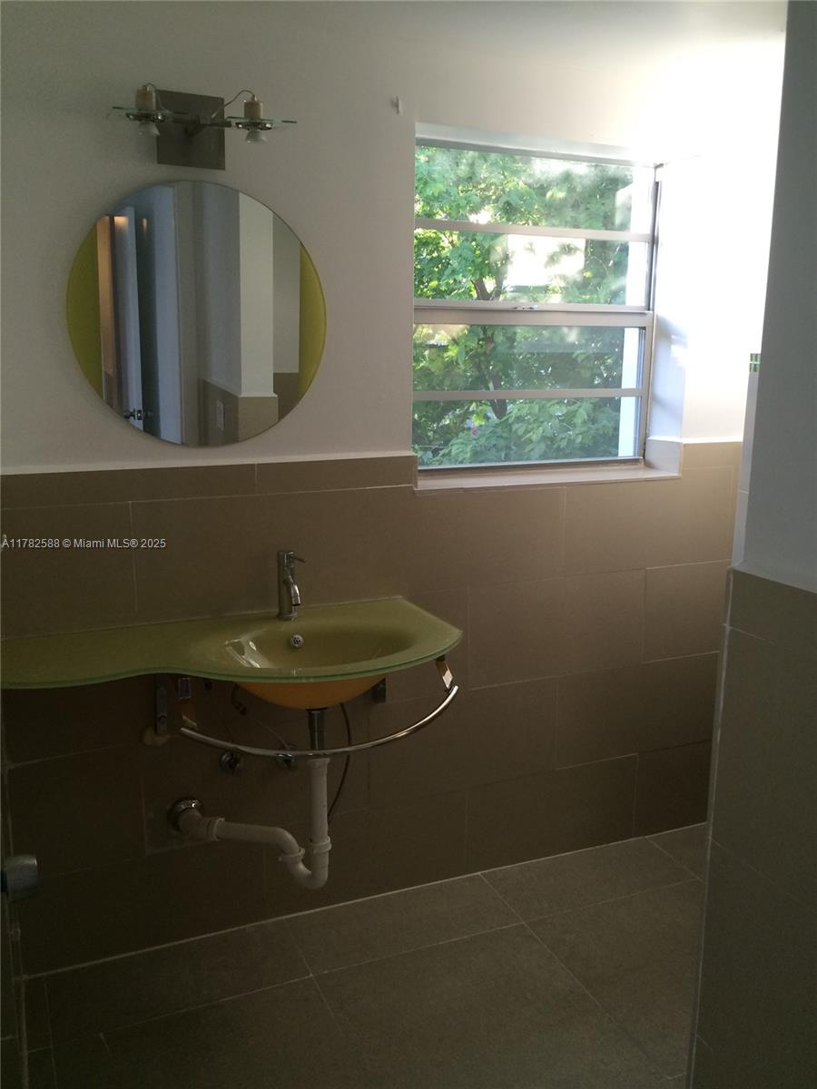 7025 Rue Granville, Unit 3 Miami Beach, FL 33141 - Photo 20 of 21 a bathroom with a sink and a mirror