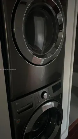 an empty room with wooden floor cabinet and windows