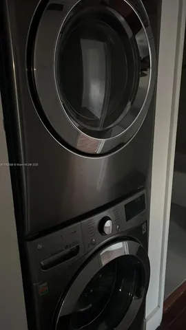 an empty room with wooden floor cabinet and windows