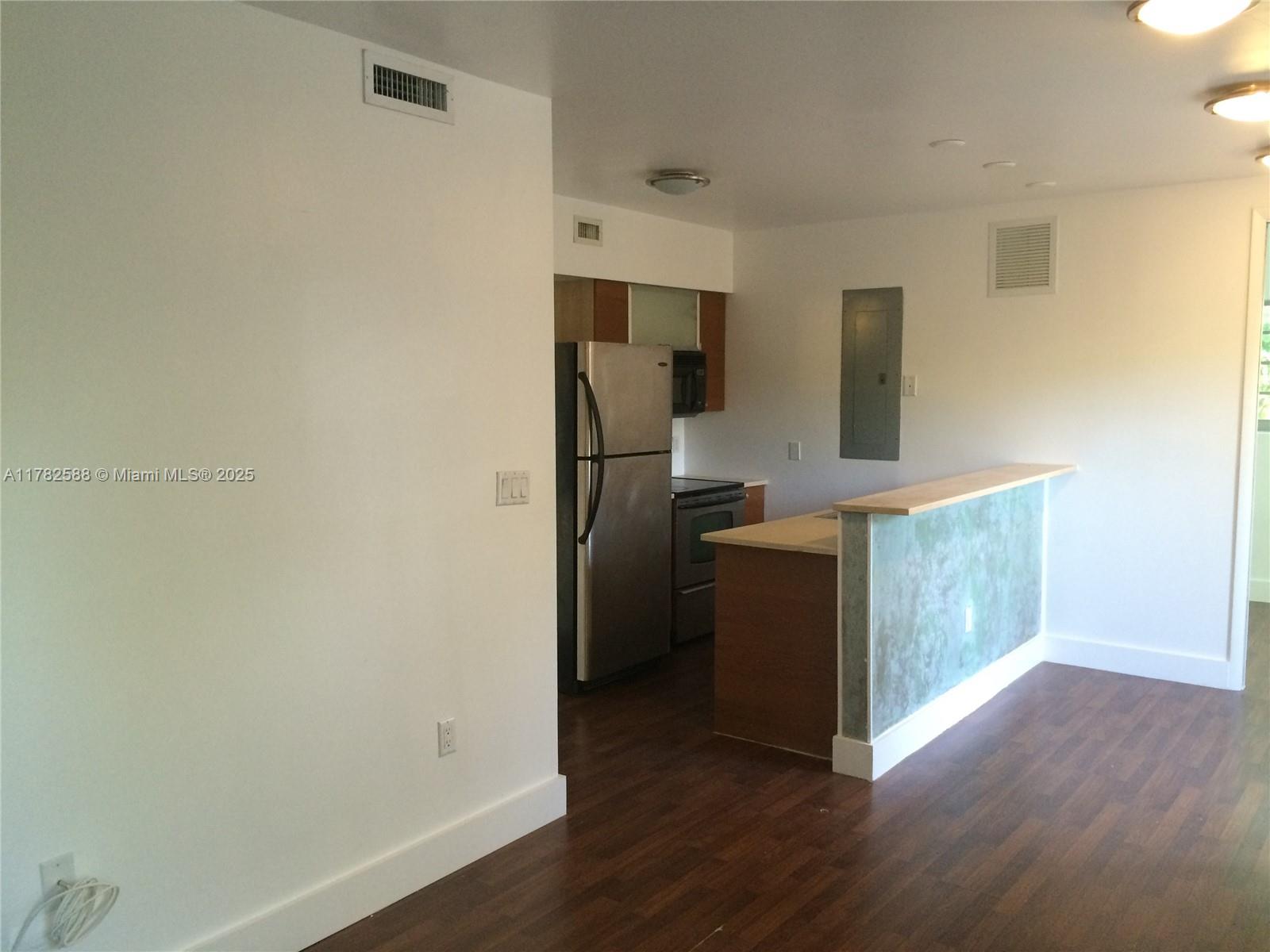 7025 Rue Granville, Unit 3 Miami Beach, FL 33141 - Photo 6 of 21 a kitchen with wooden floor and electronic appliances