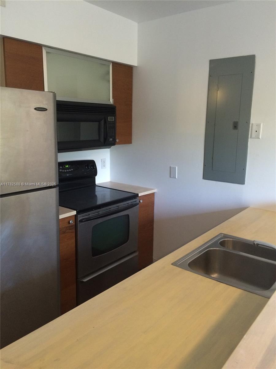 7025 Rue Granville, Unit 3 Miami Beach, FL 33141 - Photo 9 of 21 a kitchen with a refrigerator and a sink