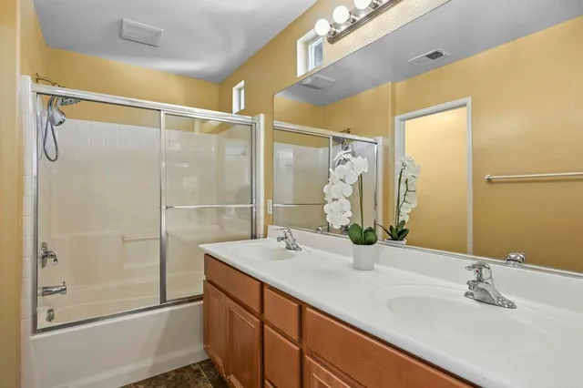 a bathroom with a double vanity sink and a mirror