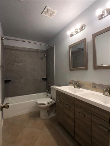 4008 Cima Serena Drive, Unit B Austin, TX 78759 - Photo 10 of 16 a bathroom with a double vanity sink mirror and toilet