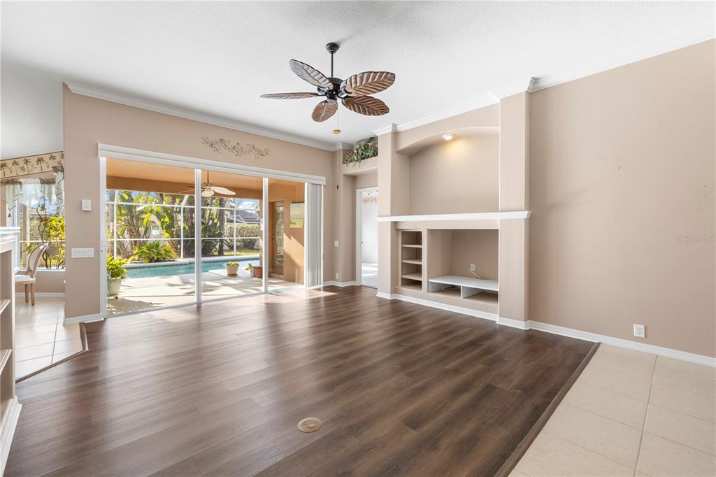 2125 Gold Dust Court New Port Richey, FL 34655 - Photo 14 of 54 an empty room with wooden floor ceiling fan and windows