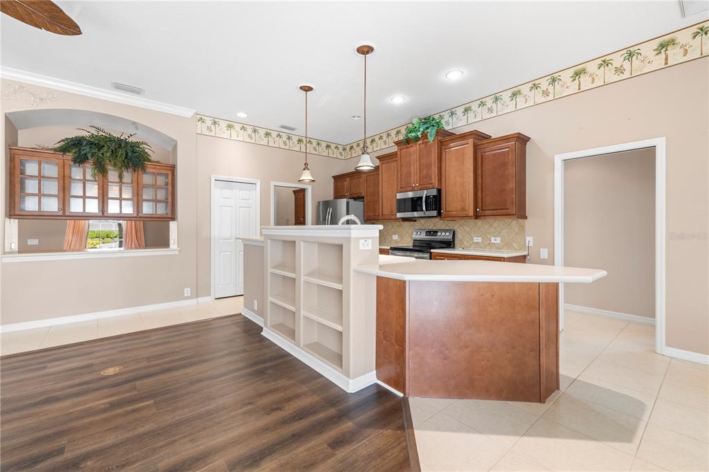 2125 Gold Dust Court New Port Richey, FL 34655 - Photo 16 of 54 a kitchen with stainless steel appliances granite countertop a refrigerator a oven a sink and white cabinets with wooden floor