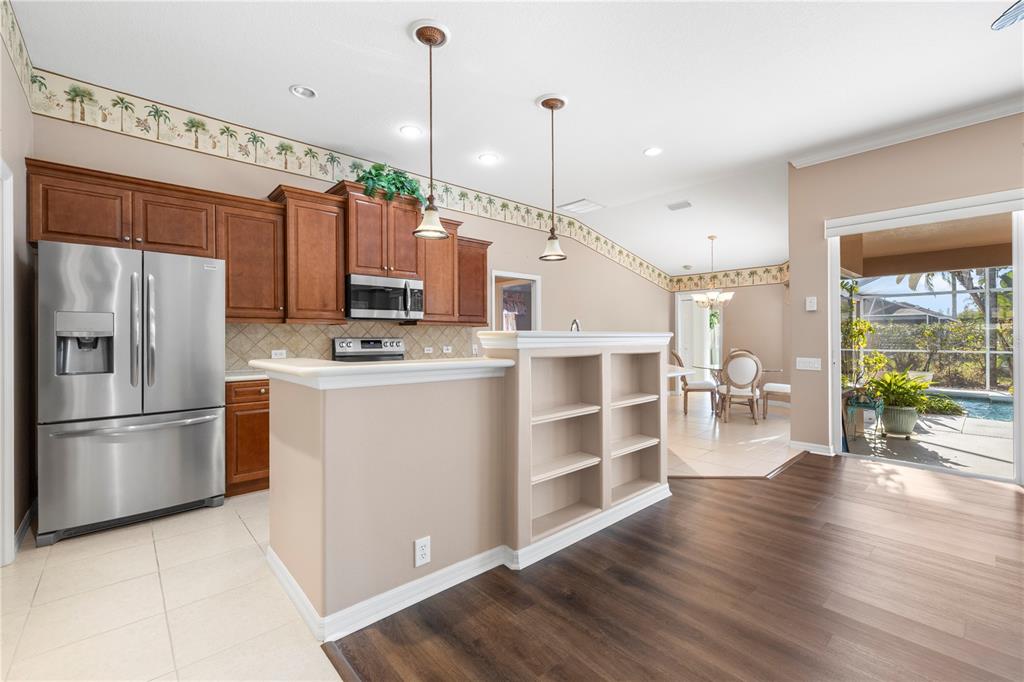 2125 Gold Dust Court New Port Richey, FL 34655 - Photo 17 of 54 a kitchen with stainless steel appliances granite countertop a refrigerator a stove and a wooden floors