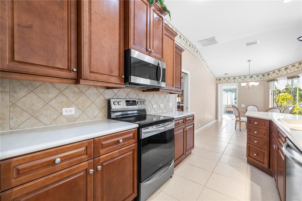 2125 Gold Dust Court New Port Richey, FL 34655 - Photo 22 of 54 a kitchen with stainless steel appliances granite countertop a stove a sink and a microwave