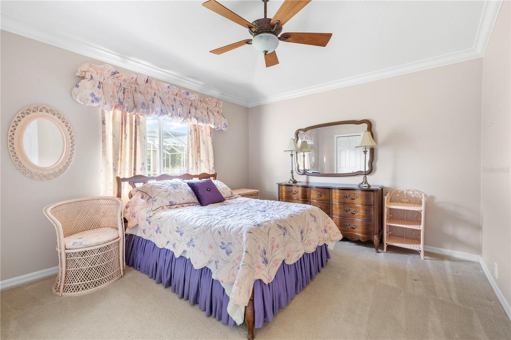 2125 Gold Dust Court New Port Richey, FL 34655 - Photo 30 of 54 a bedroom with a bed a chandelier and mirror