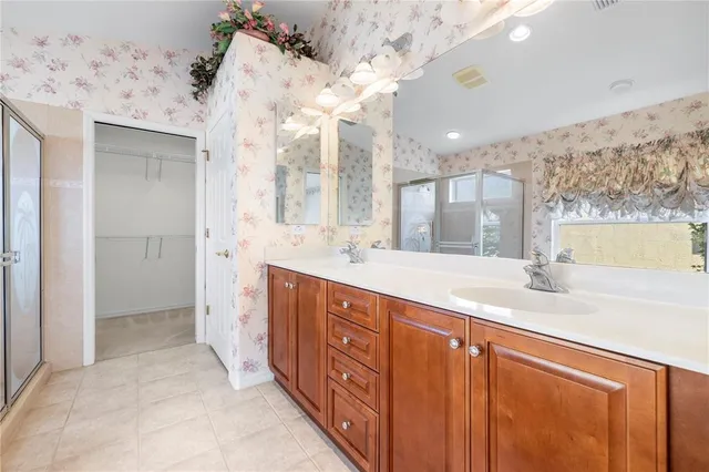 a spacious bathroom with a double vanity sink and a large mirror