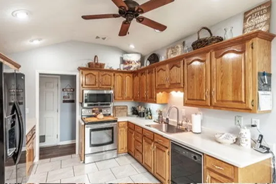 a kitchen with stainless steel appliances granite countertop a stove refrigerator and a sink