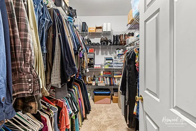 a view of walk in closet with clothes and shoes