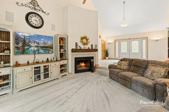a living room with furniture a flat screen tv and a fireplace