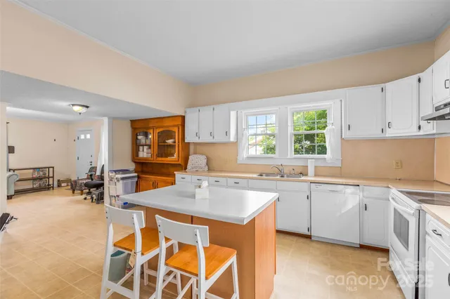 a kitchen with a sink and chairs