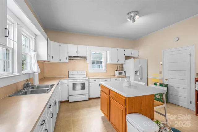a kitchen with a sink refrigerator and cabinets