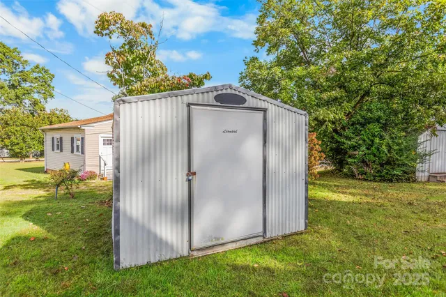 a backyard of a house with plants and large tree