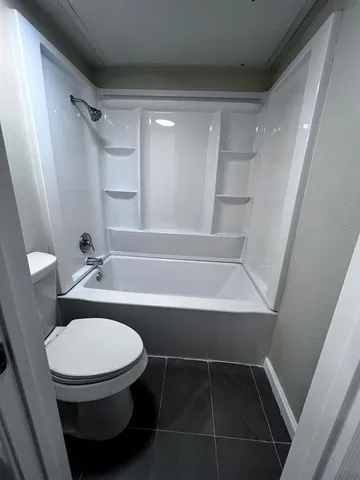 a bathroom with a shower a toilet and a sink