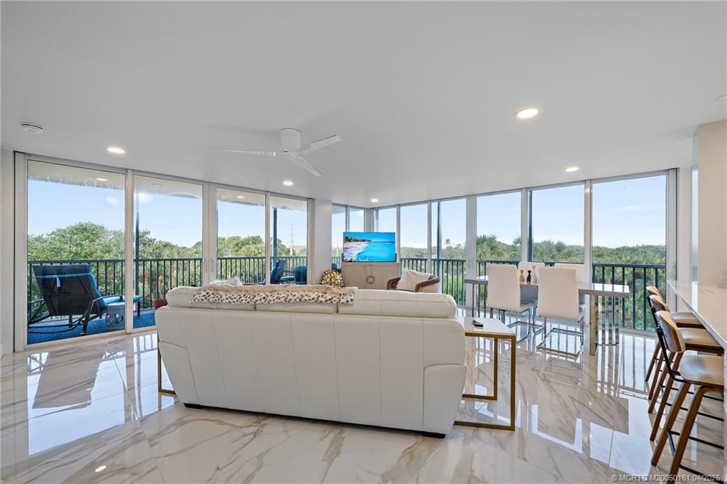 669 Northeast Plantation Road, Unit 201 Stuart, FL 34996 - Photo 17 of 37 a living room with furniture and a large window