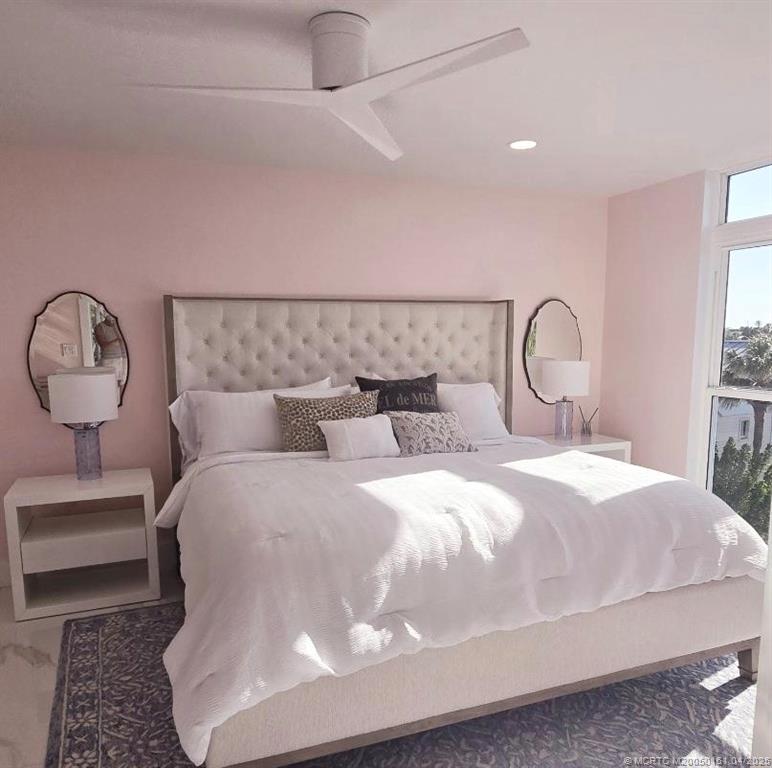 669 Northeast Plantation Road, Unit 201 Stuart, FL 34996 - Photo 24 of 37 a bedroom with a bed and a lamp