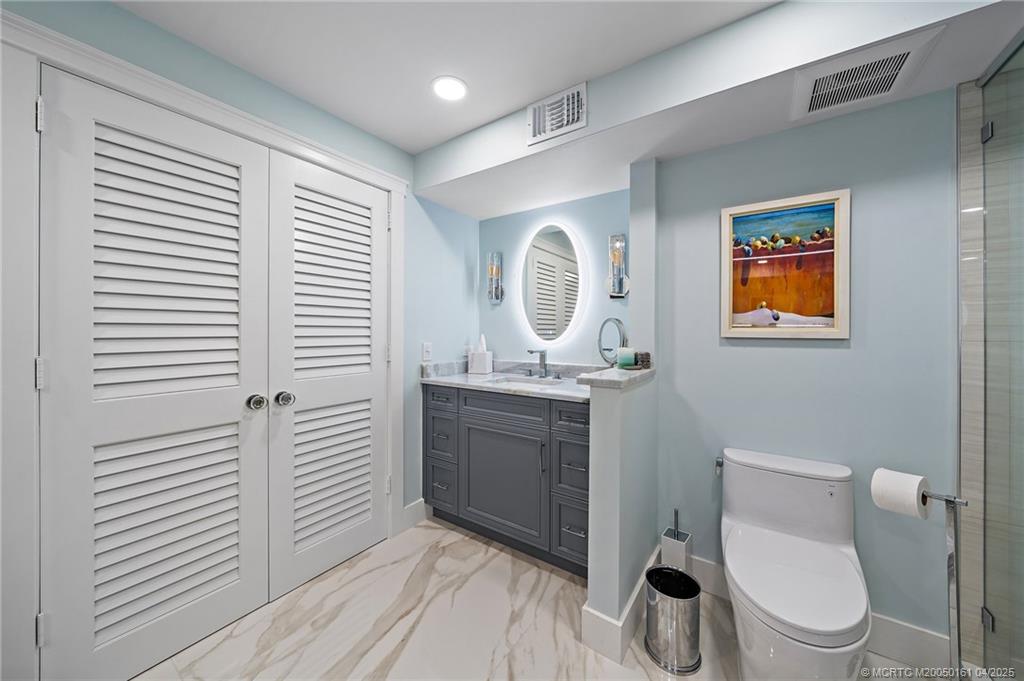 669 Northeast Plantation Road, Unit 201 Stuart, FL 34996 - Photo 27 of 37 a bathroom with a toilet a sink and mirror