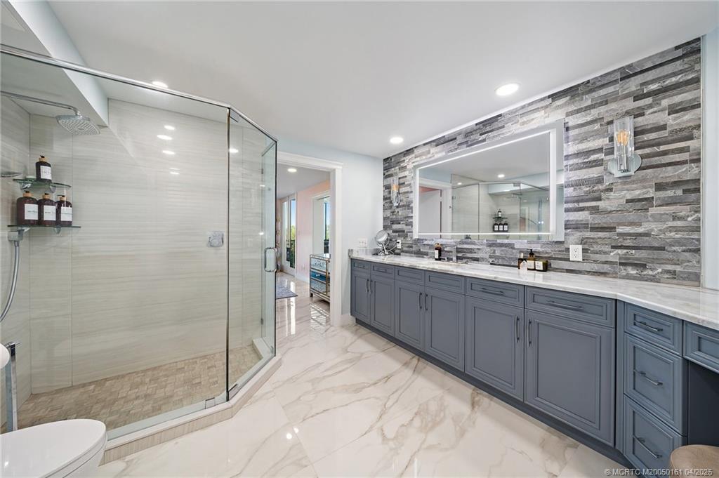 669 Northeast Plantation Road, Unit 201 Stuart, FL 34996 - Photo 28 of 37 a bathroom with a double vanity sink toilet and shower