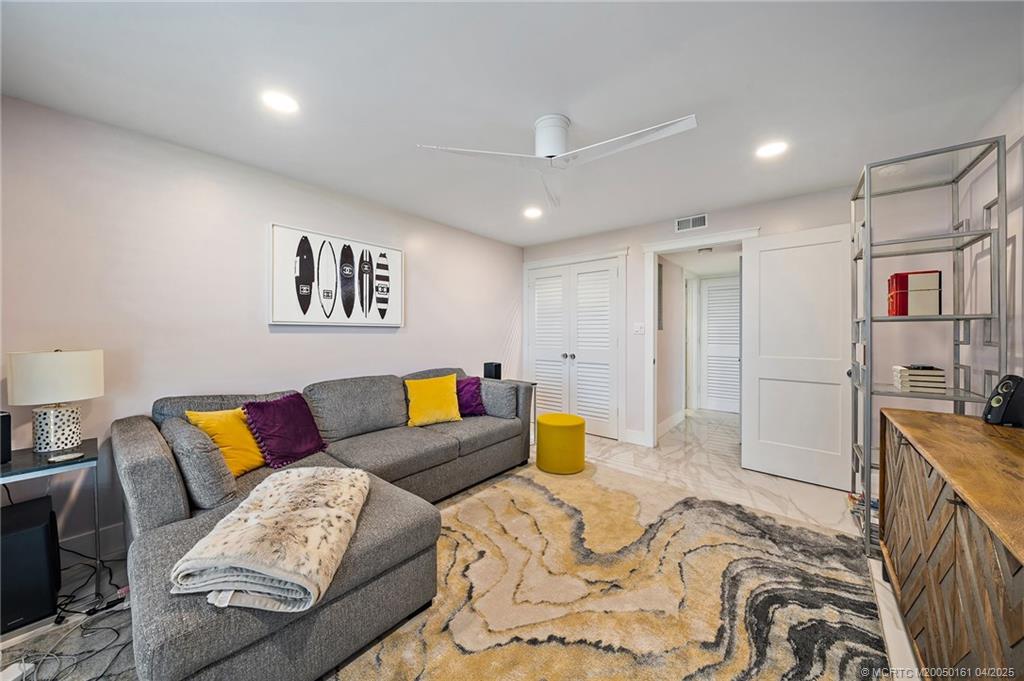 669 Northeast Plantation Road, Unit 201 Stuart, FL 34996 - Photo 31 of 37 a spacious bedroom with a bed a couch and dresser