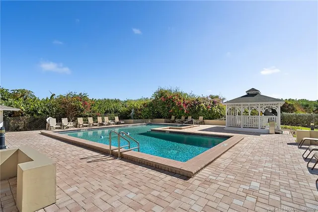 a view of a livingroom with wooden floor and a refrigerator