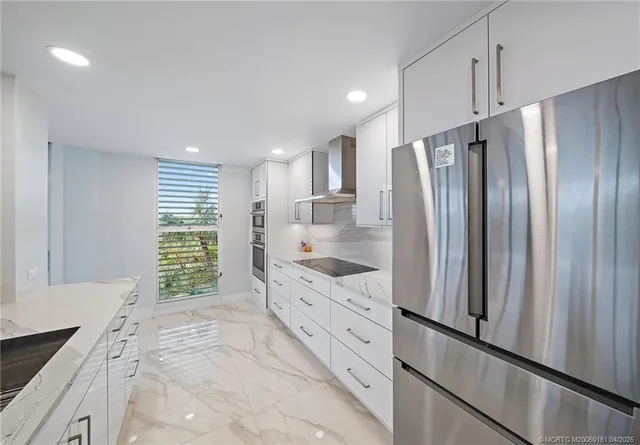 a kitchen with stainless steel appliances kitchen island granite countertop a stove and a refrigerator