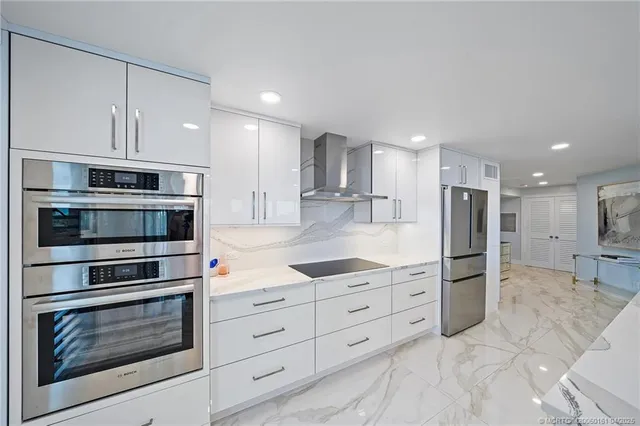 a kitchen with stainless steel appliances granite countertop a refrigerator and a counter space