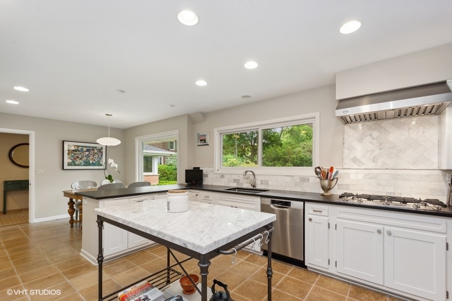 535 Dundee Road Glencoe, IL 60022 - Photo 11 of 37 a kitchen with stainless steel appliances granite countertop sink stove and white cabinets with wooden floor
