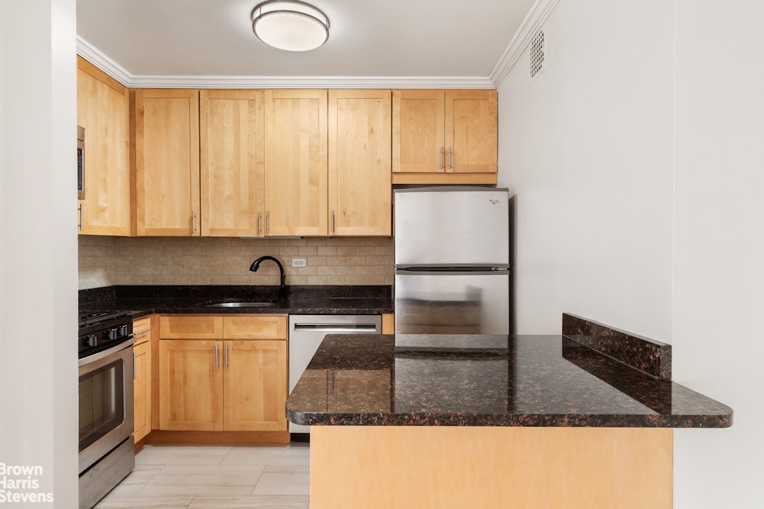 300 East 40th Street, Unit 12P Manhattan, NY 10016 - Photo 2 of 13 a kitchen with granite countertop a sink a stove and cabinets
