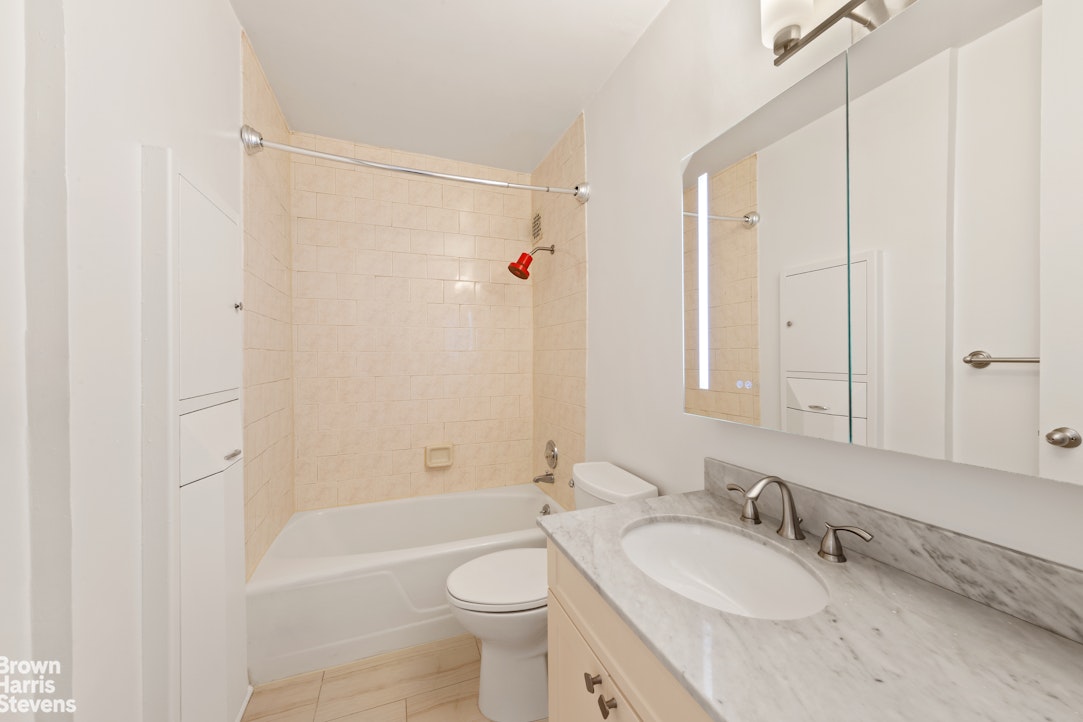300 East 40th Street, Unit 12P Manhattan, NY 10016 - Photo 6 of 13 a bathroom with a granite countertop sink toilet and shower