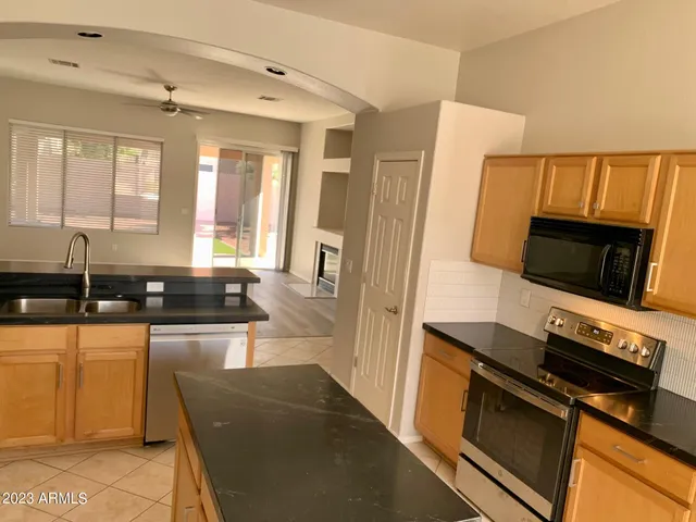 a kitchen with granite countertop a refrigerator and a stove top oven