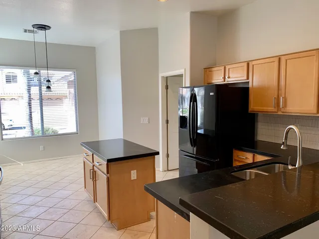 a kitchen with stainless steel appliances granite countertop a refrigerator a sink and a stove