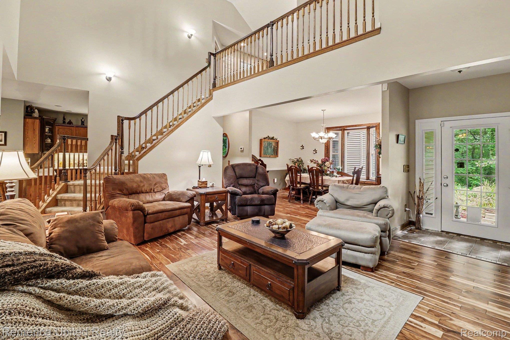 20962 Wasson Road Gregory, MI 48137 - Photo 5 of 39 Two-story living area featuring wood-finish flooring and a grand staircase with wood balusters