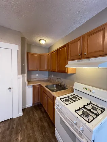 a view of a kitchen with a sink and a refrigerator