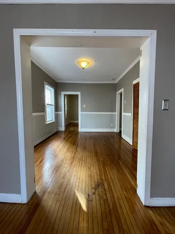 a view of empty room with wooden floor