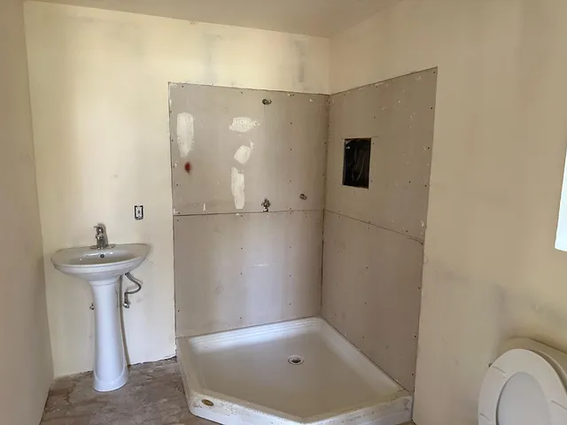 a white house that has tree in front of it