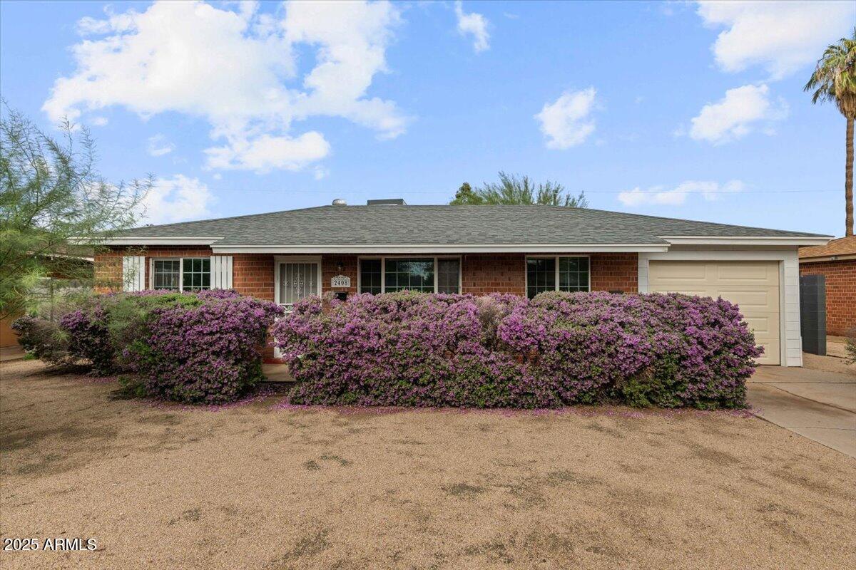 a front view of house with garden and trees