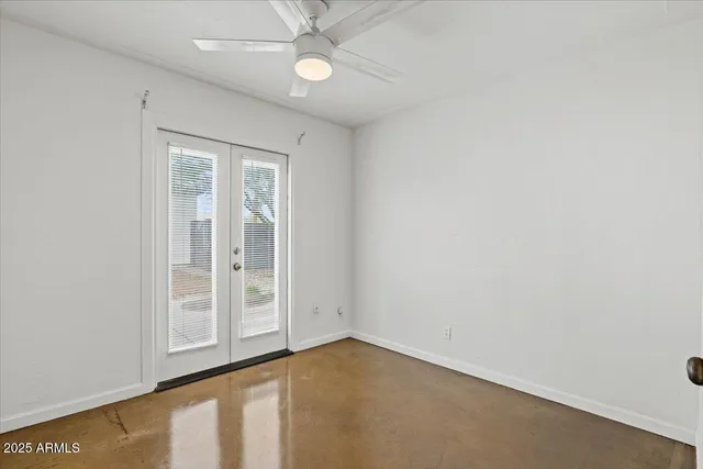 an empty room with a ceiling fan and carpet