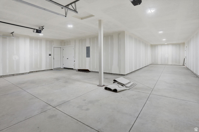 1315 West 3200 South, Unit 17 Perry, UT 84302 - Photo 48 of 58 Spacious garage featuring concrete flooring, unpainted drywall, recessed lighting, and exposed garage door opener mechanisms
