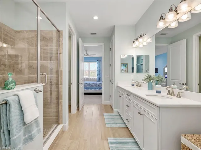 a bathroom with a double vanity sink mirror and shower