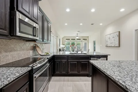 a kitchen with stainless steel appliances granite countertop a sink and stove