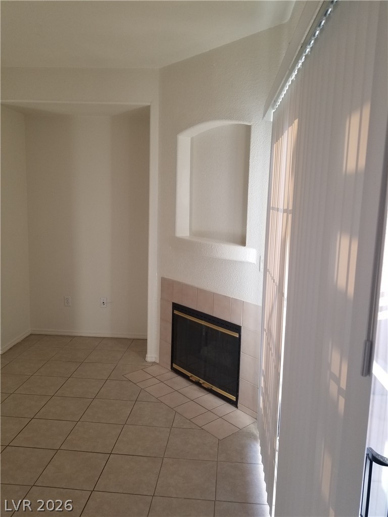 4730 East Craig Road, Unit 1154 Las Vegas, NV 89115 - Photo 3 of 13 A cozy living space features a tiled fireplace with an integrated arched niche and durable tile flooring.