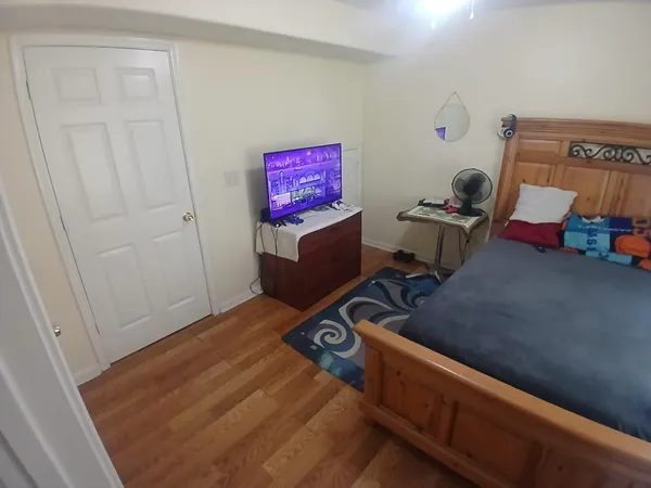 a bedroom with a bed and wooden floor