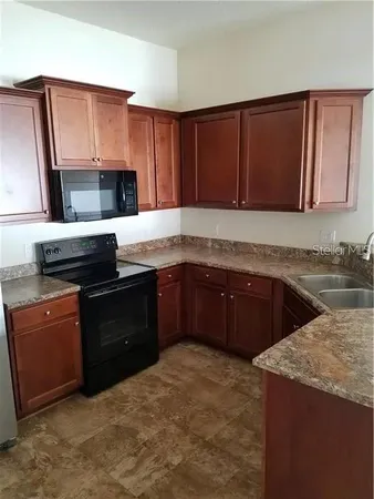 a kitchen with stainless steel appliances granite countertop a stove a sink and a microwave