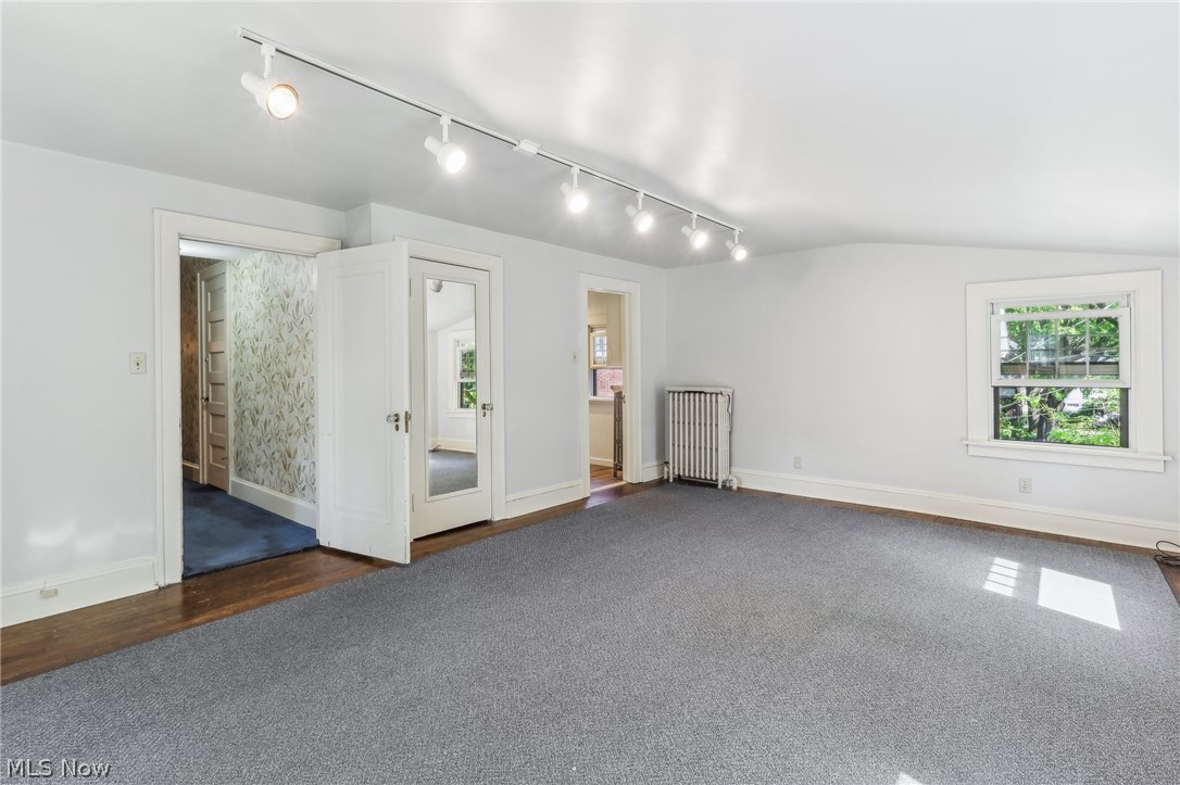 2329 Stillman Road Cleveland, OH 44118 - Photo 28 of 49 Bedroom with vaulted ceiling, dark carpet, rail lighting, and radiator heating unit