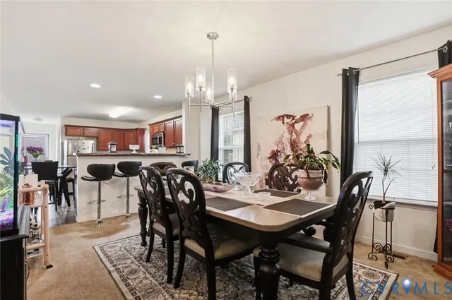 a view of a dining room with furniture and a chandelier