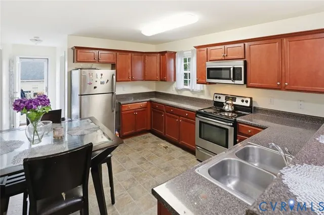 a kitchen with stainless steel appliances granite countertop a refrigerator sink and microwave