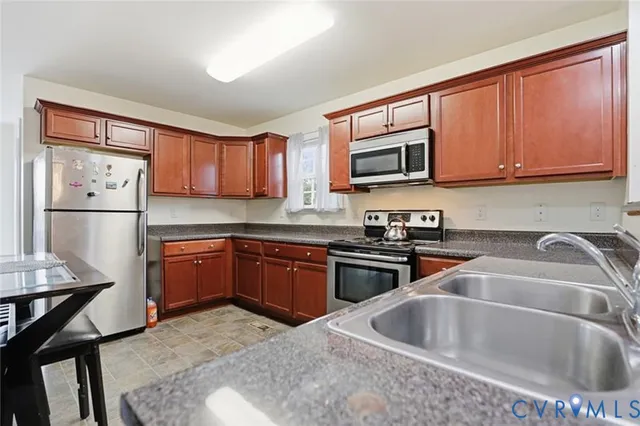 a kitchen with sink a microwave and cabinets